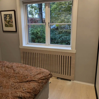 Radiatorskjuler i lekkert design i eikefinèr på soverom